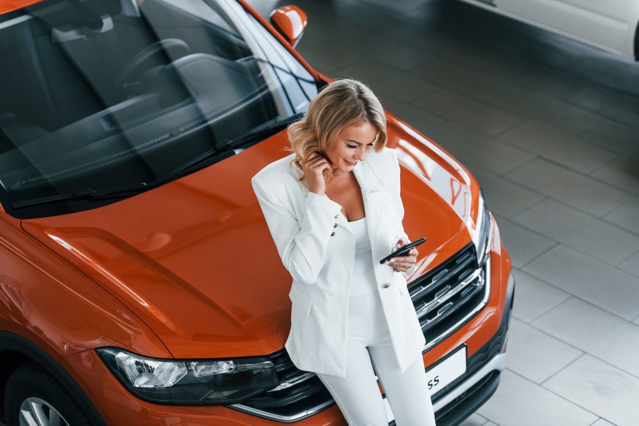 Women leaning on orange car